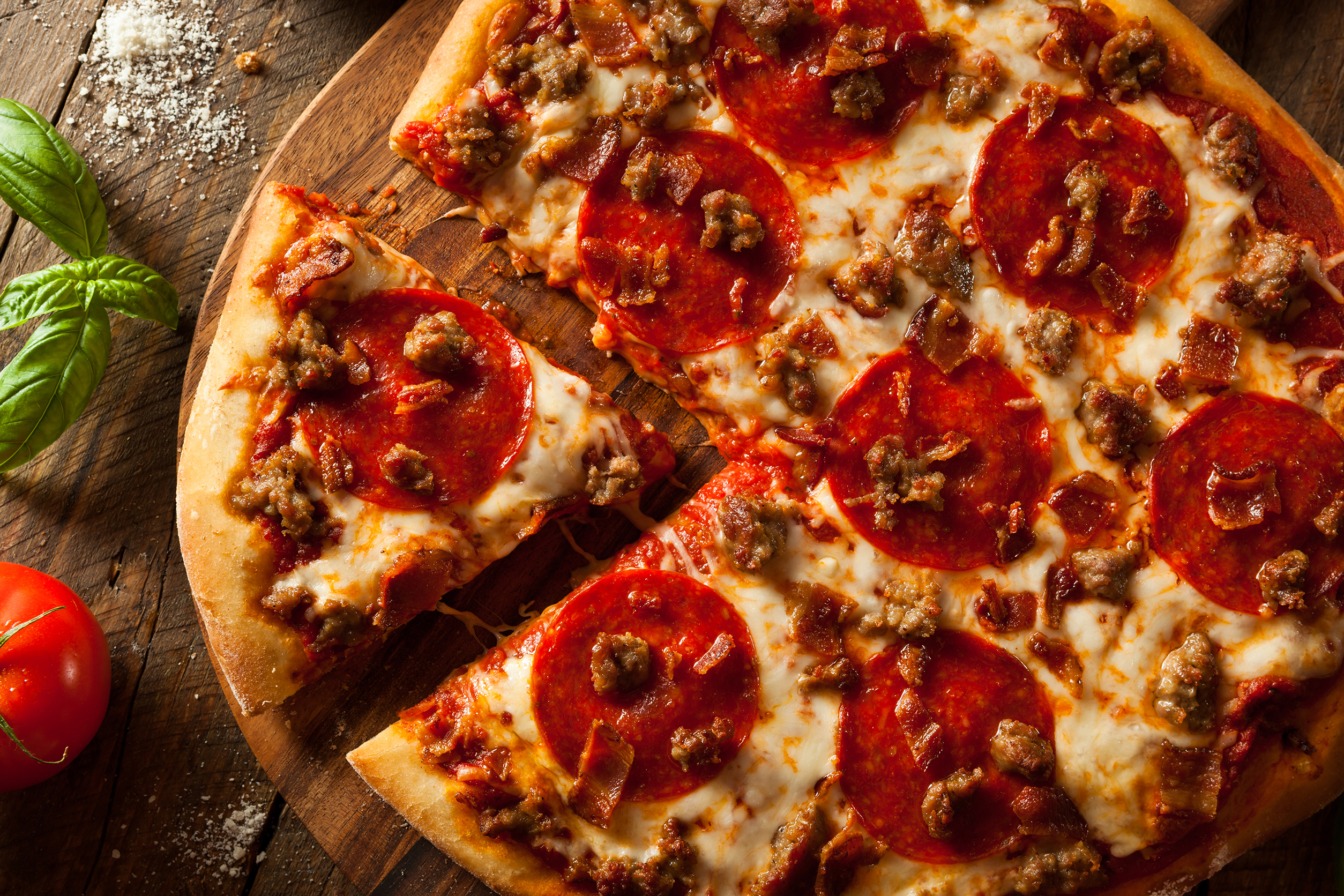 Pepperoni Pizza with tomato and mint leaves on table Pepperoni Pizza with tomato and mint leaves on table